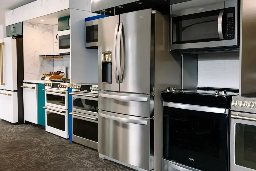 A showroom filled with a variety of stainless steel appliances.