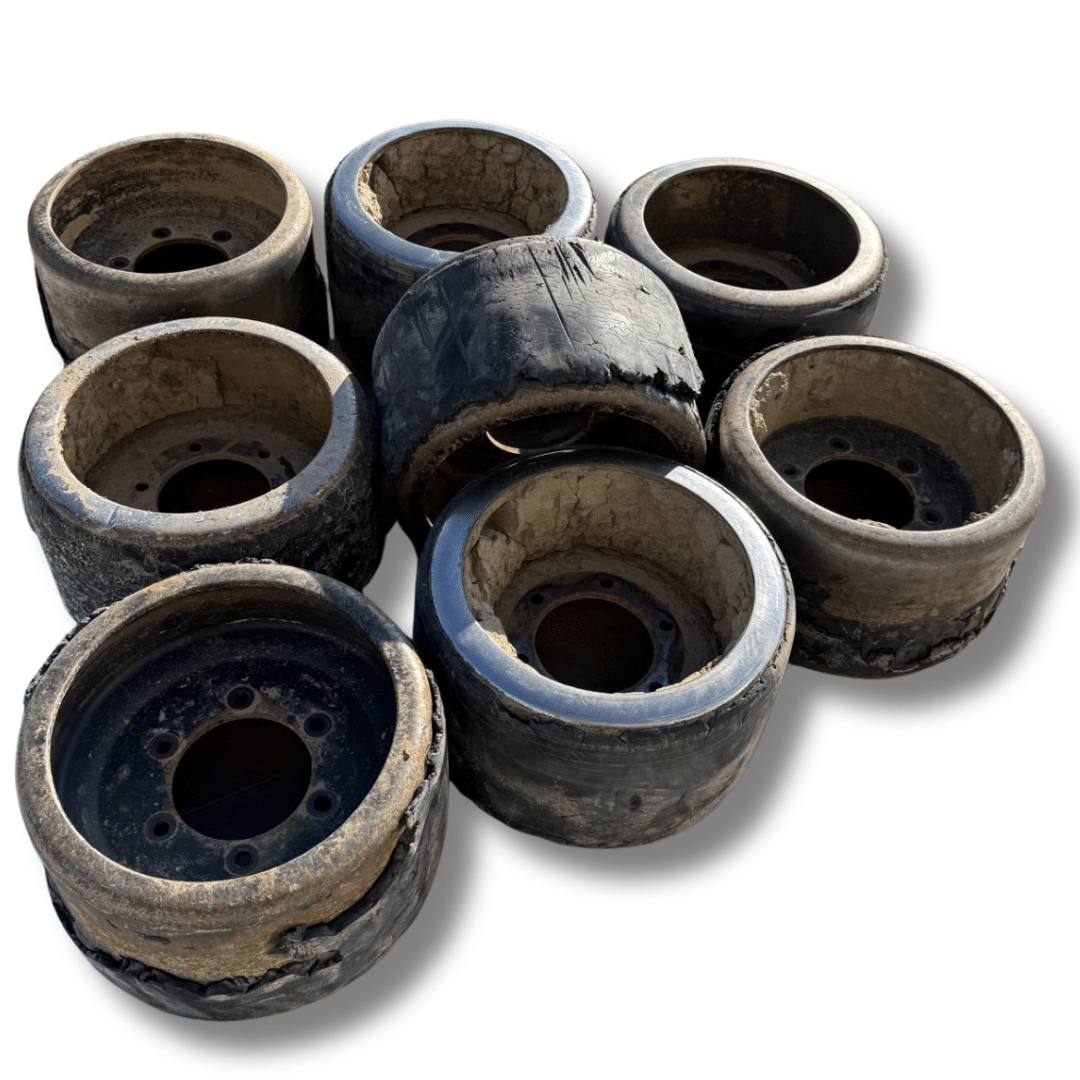 Seven worn, dusty rubber wheel rims arranged in a cluster on a white background