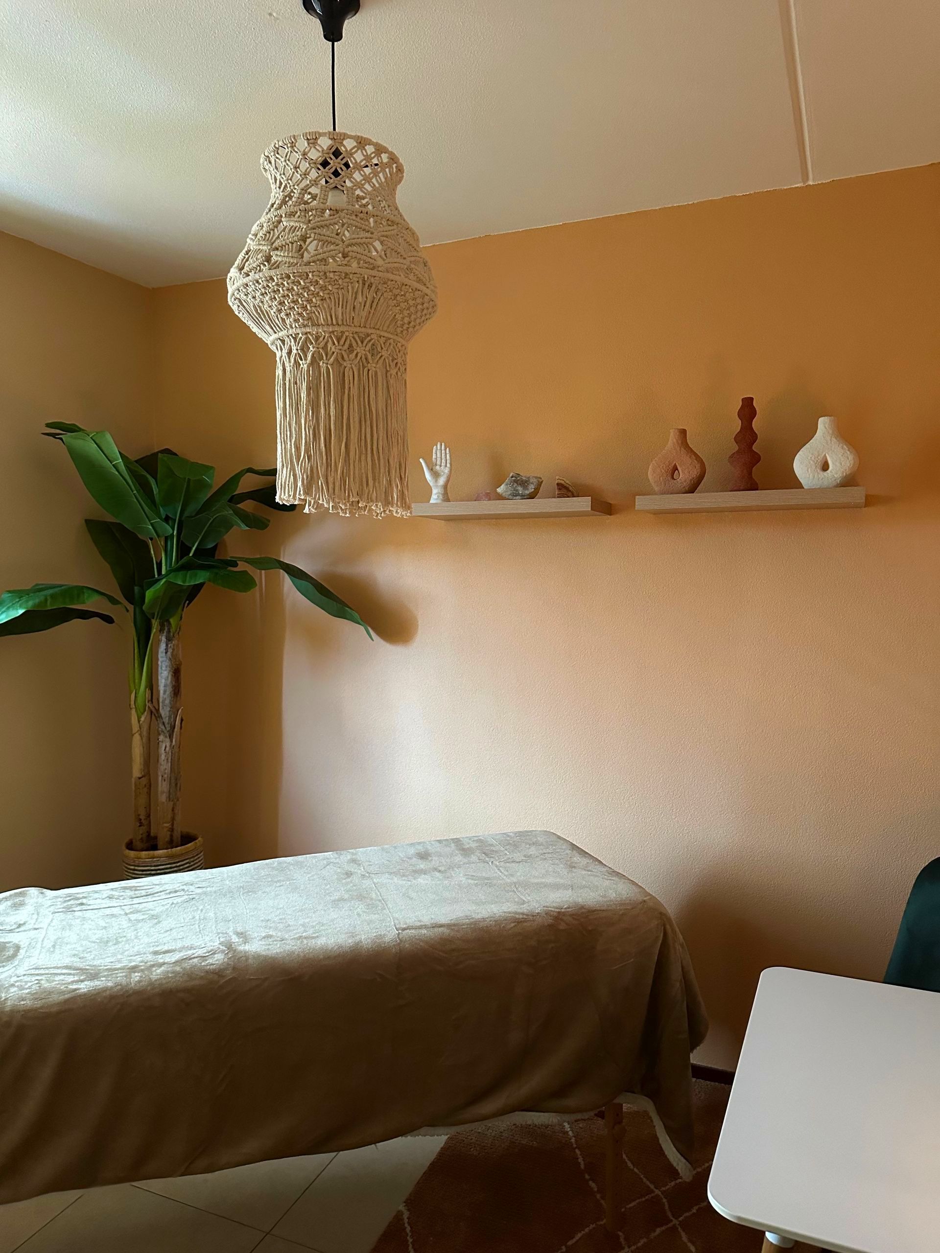 Een kamer met een tafel en een lamp die aan het plafond hangt