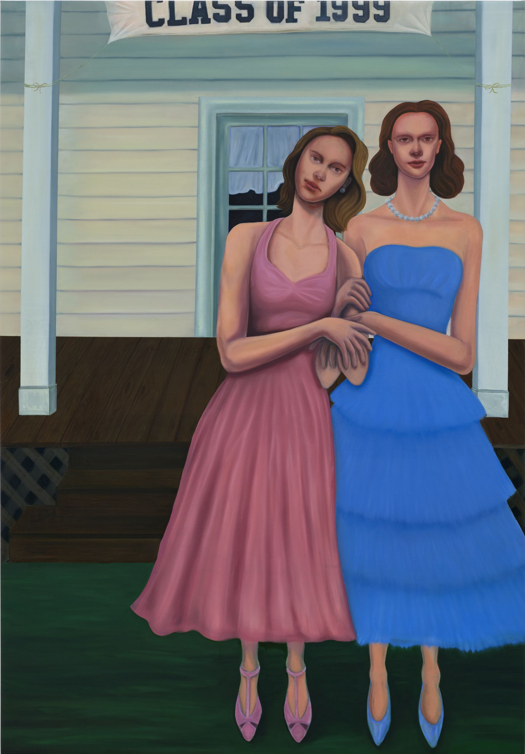 Two women in dresses, posed in front of a school with a 