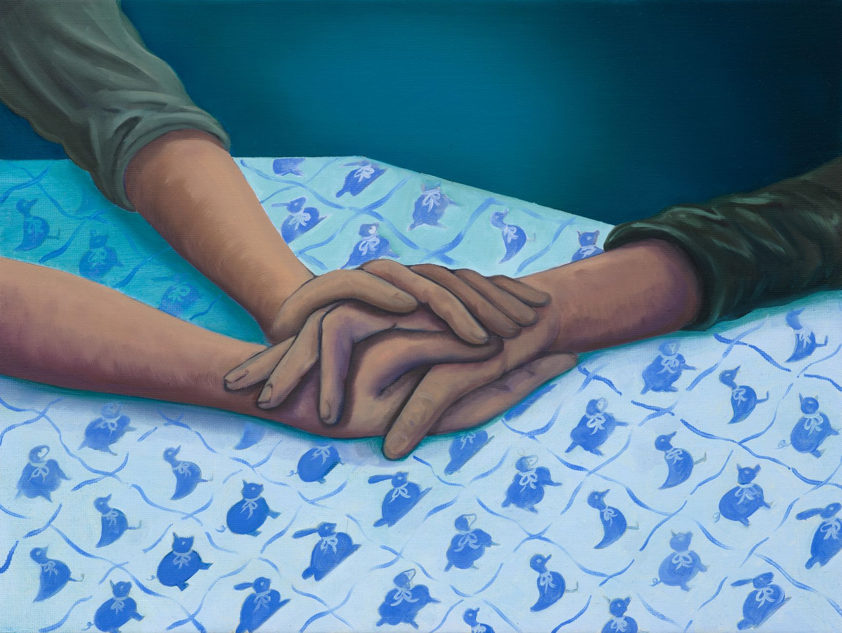 Two sets of hands clasped together, resting on a blue patterned surface. Arms and sleeves are visible; one green, one lighter.