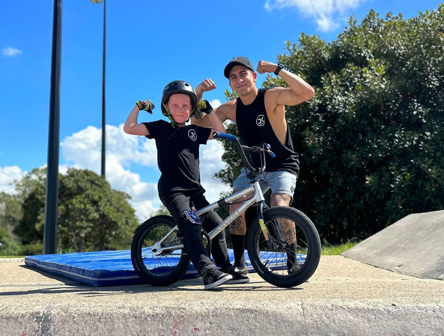A man and a boy are standing next to a bicycle.