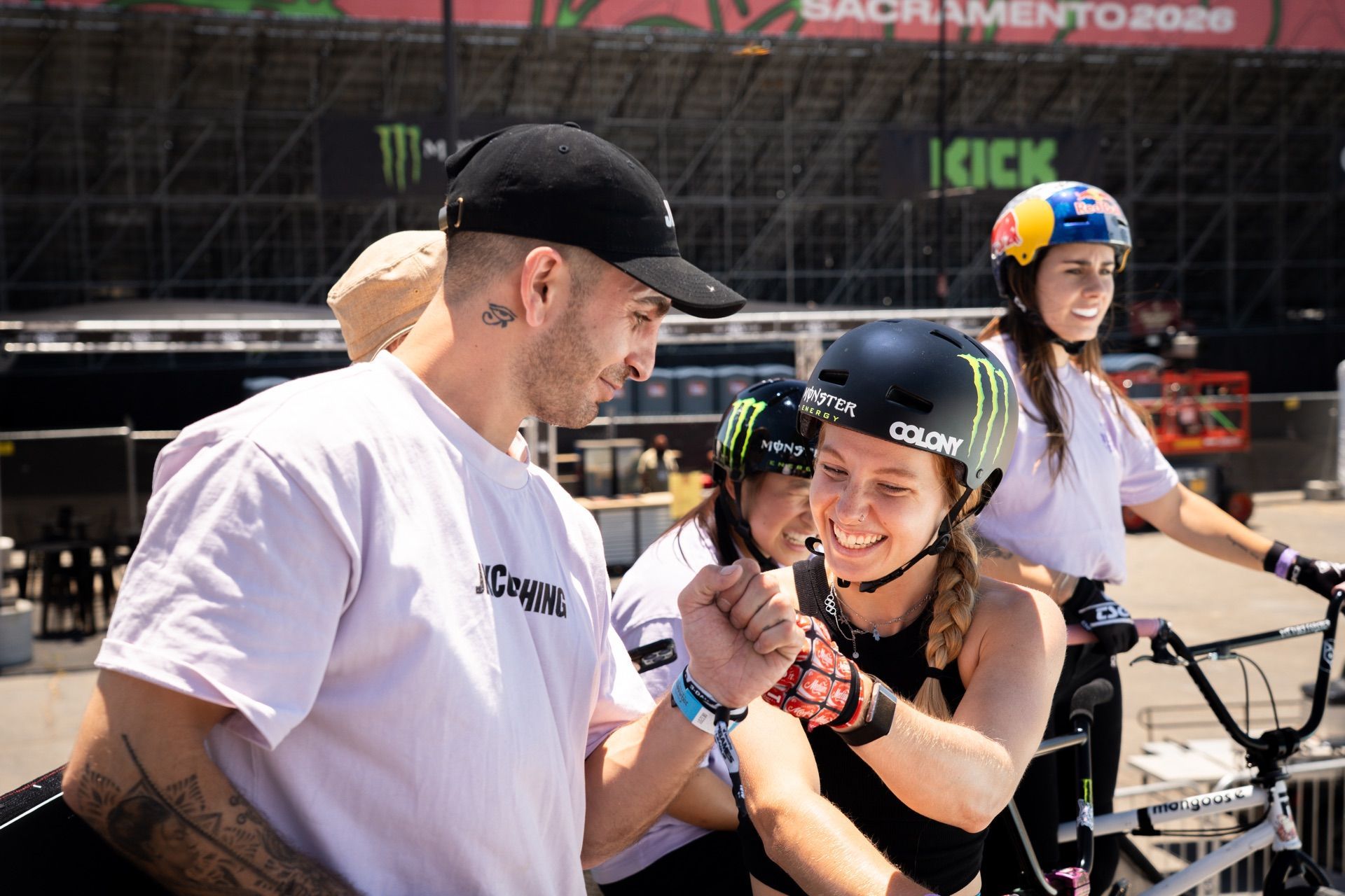 Coach and BMX riders sharing a fist bump at X Games