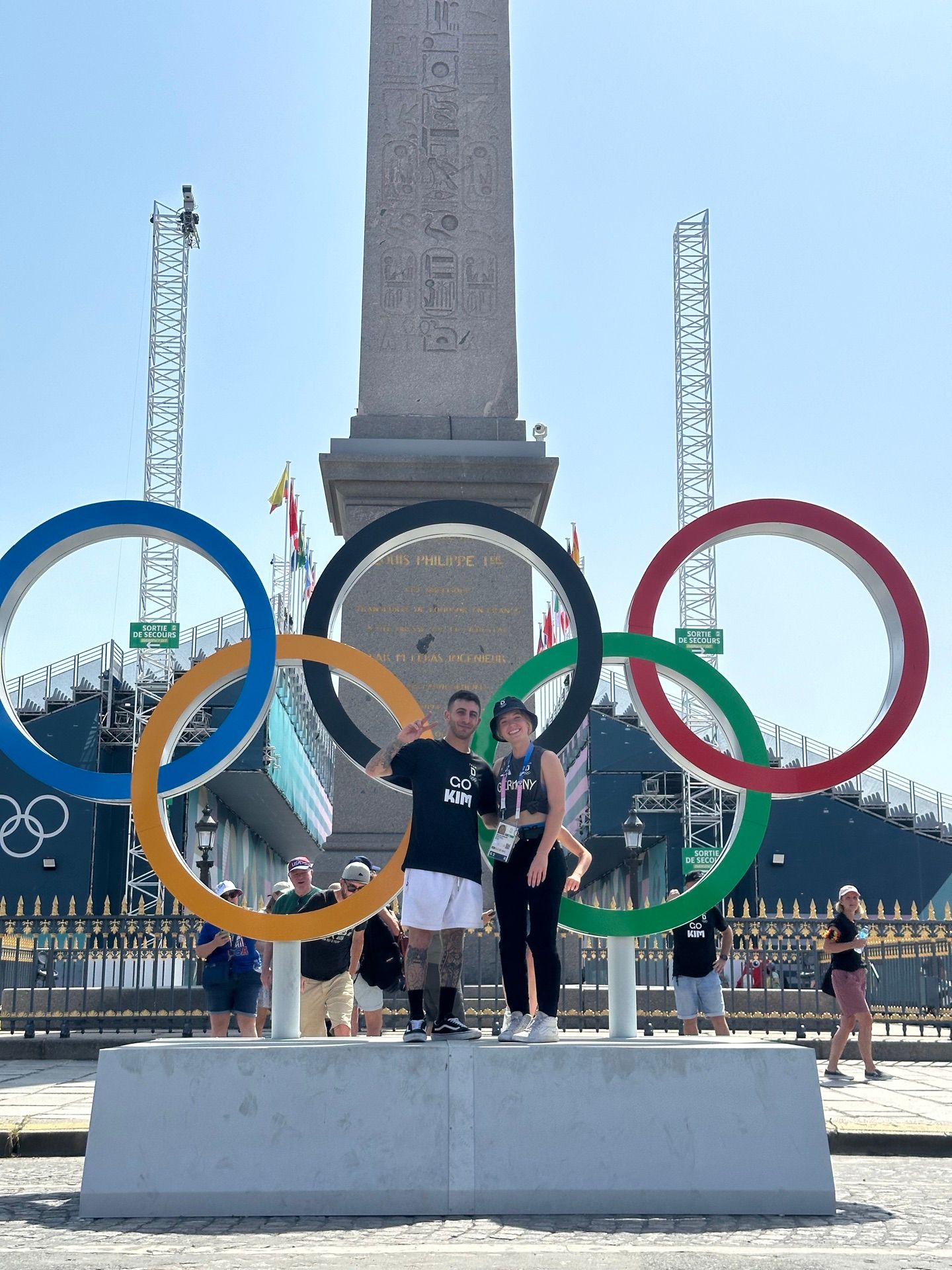 Coach and rider beside the Olympic rings