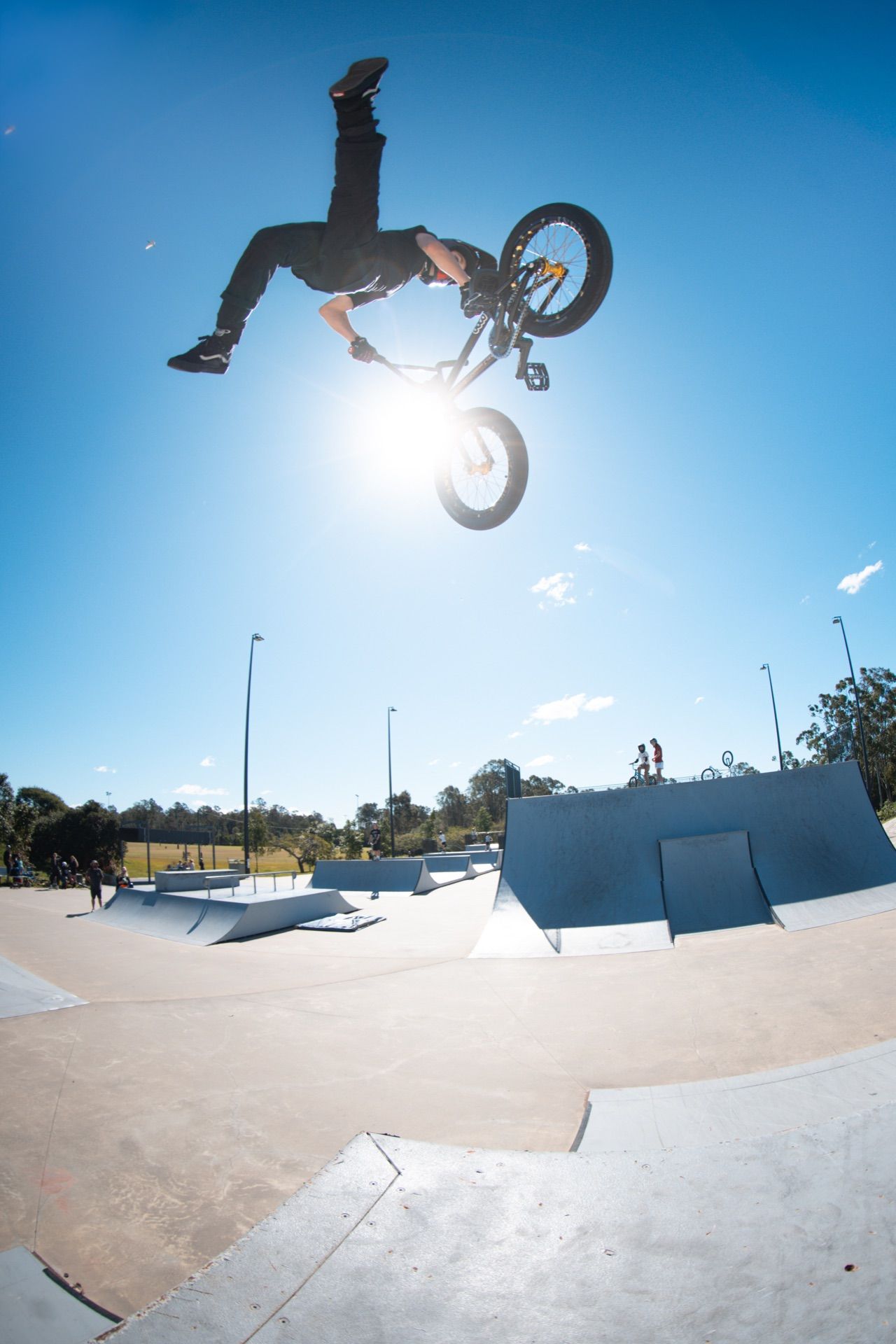 BMX rider performing an aerial trick above the skatepark