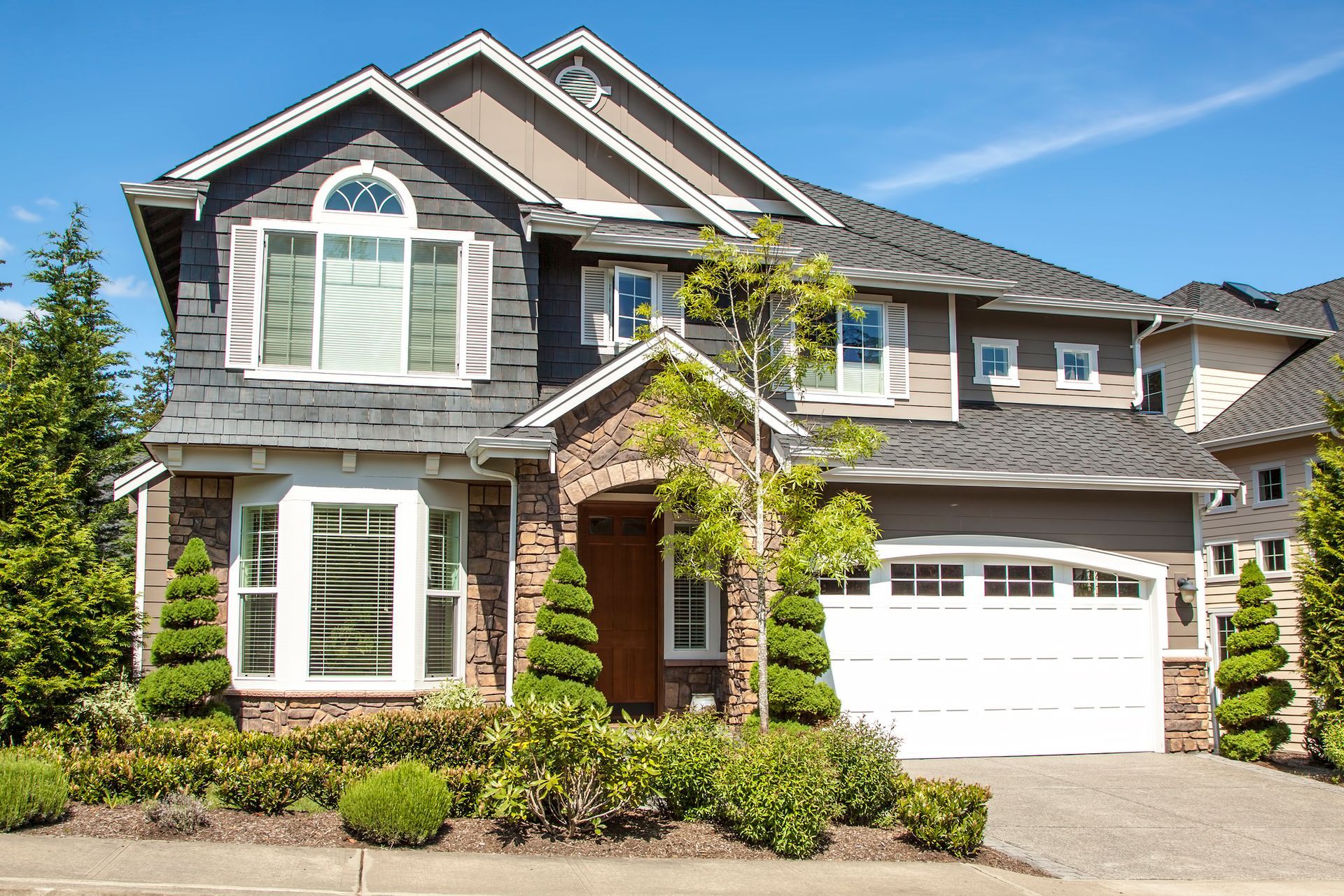 A large house with a white garage door and a lot of windows