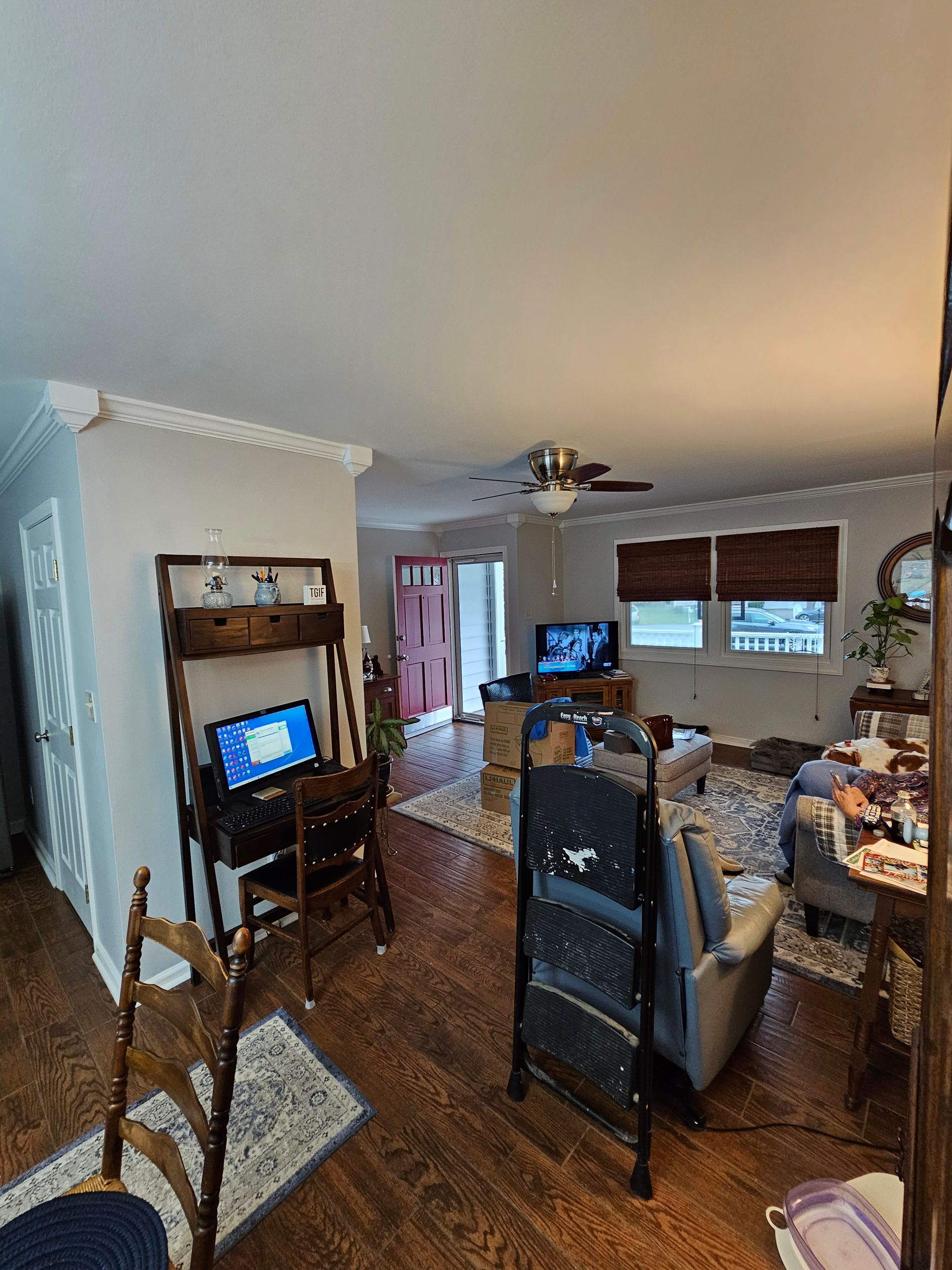 Dining room and living area with TV, wooden hutch, table, chairs, and hardwood floors