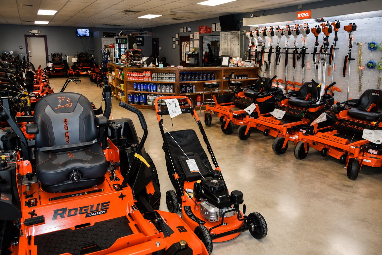 Showroom with rows of orange riding lawn mowers and garden equipment