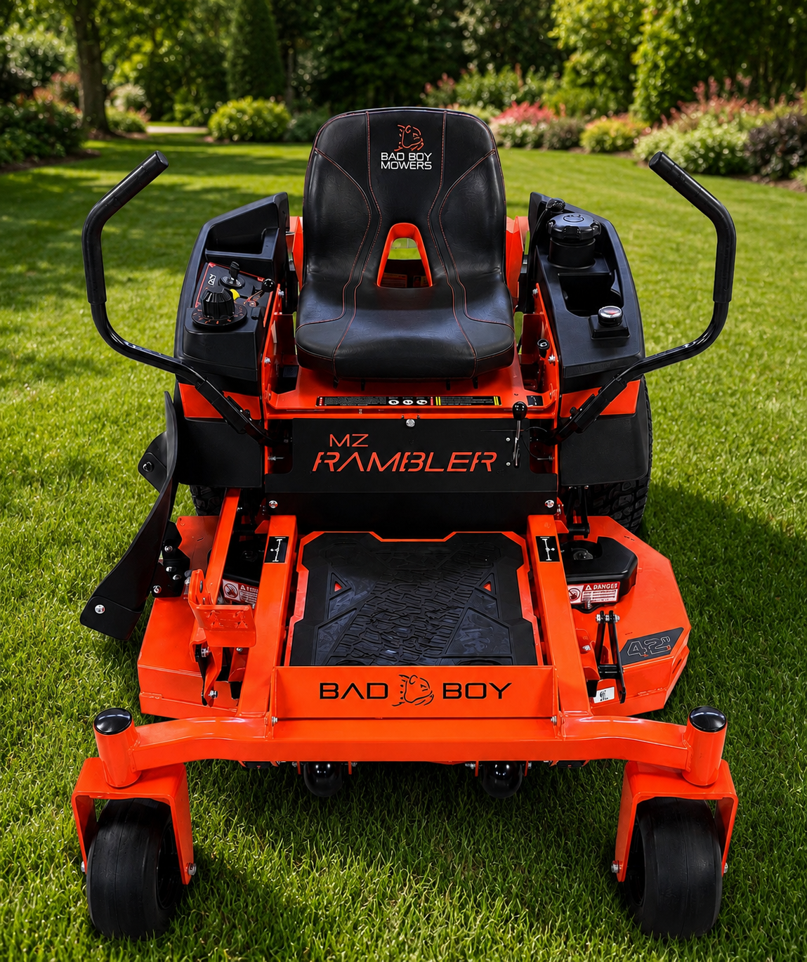 Orange Bad Boy lawn mower in a grassy yard, front view with black seat and handles