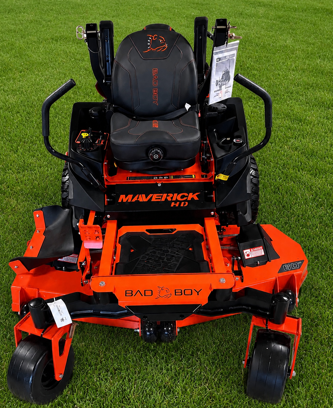 Orange and black zero-turn lawn mower on grass, front view