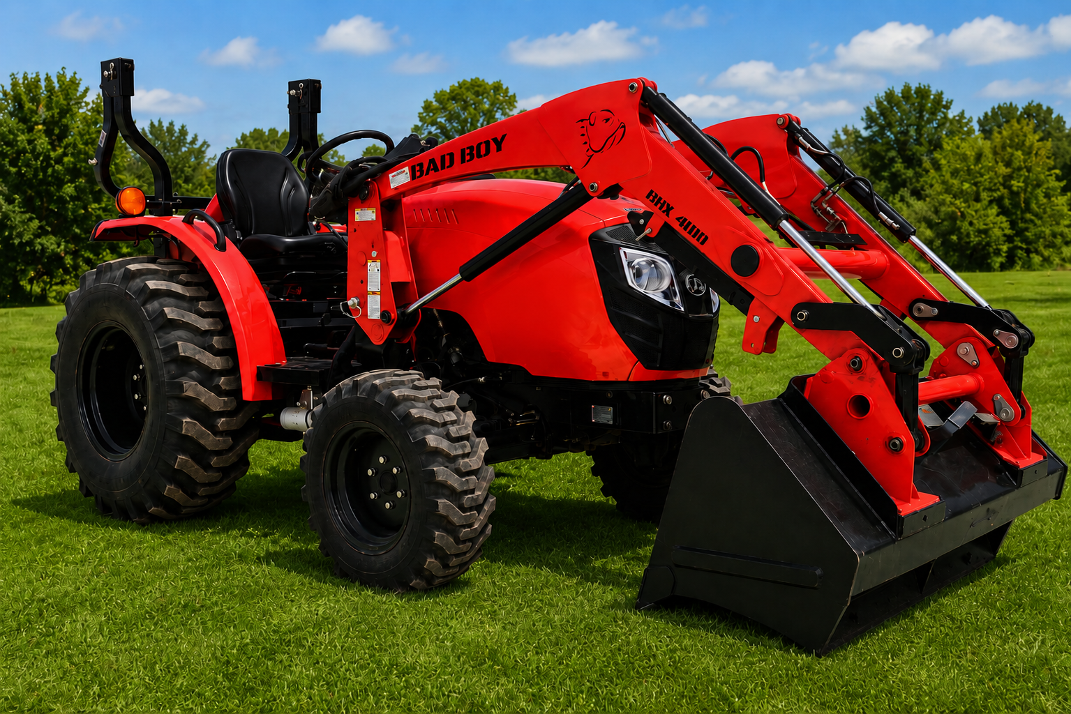 Red tractor with front loader on grass, outdoors near trees