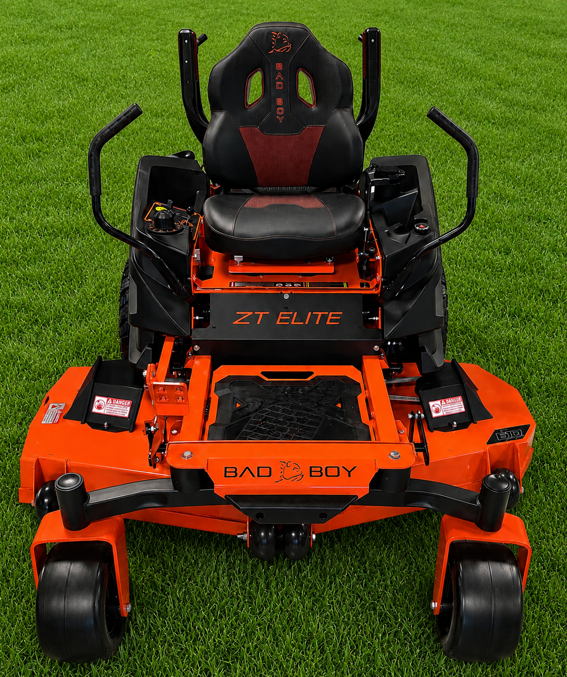 Orange-and-black zero-turn lawn mower on grass, front view, with black seat and roll bars