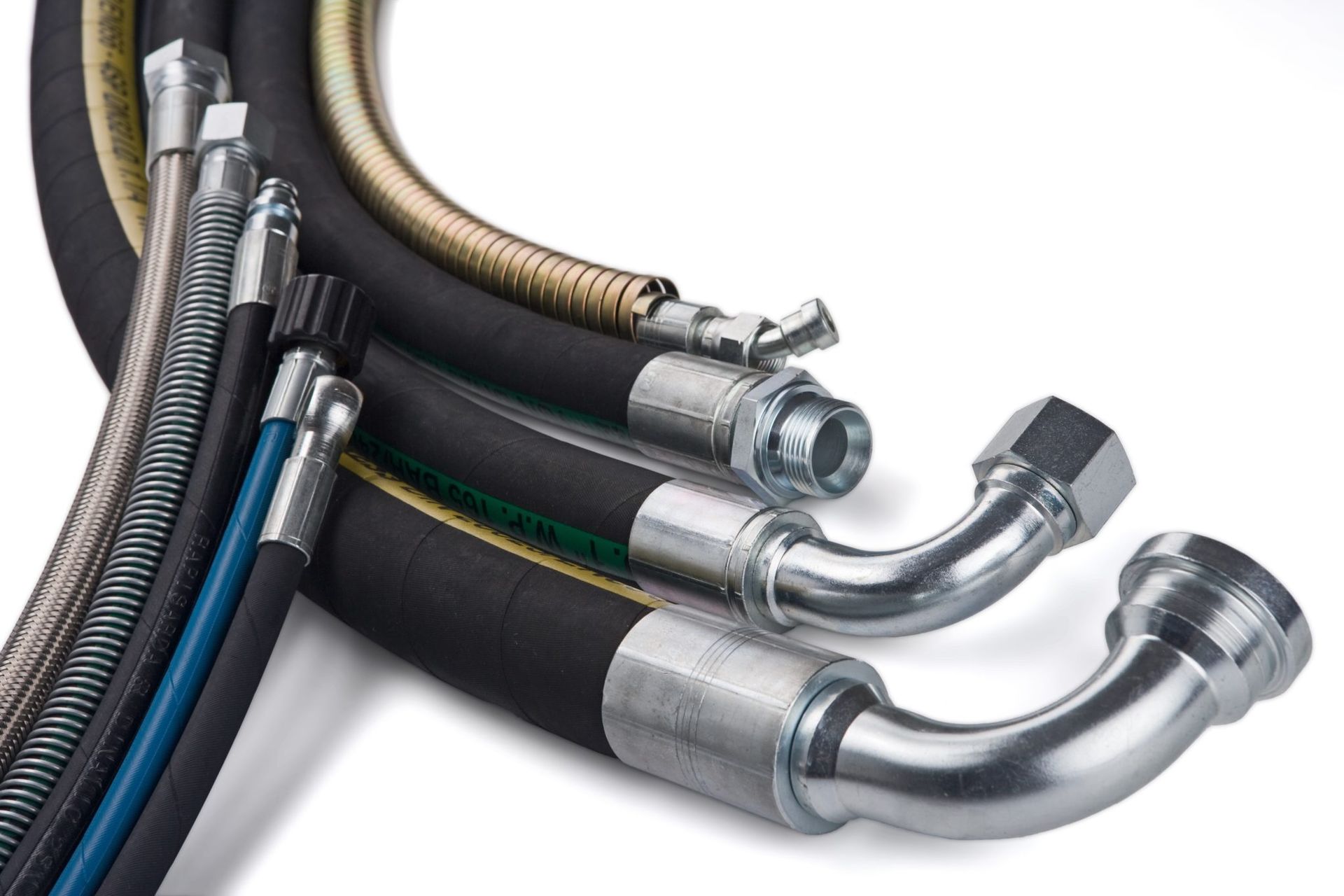 Assorted industrial hydraulic hoses with metal fittings, black and silver, arranged in a bundle.