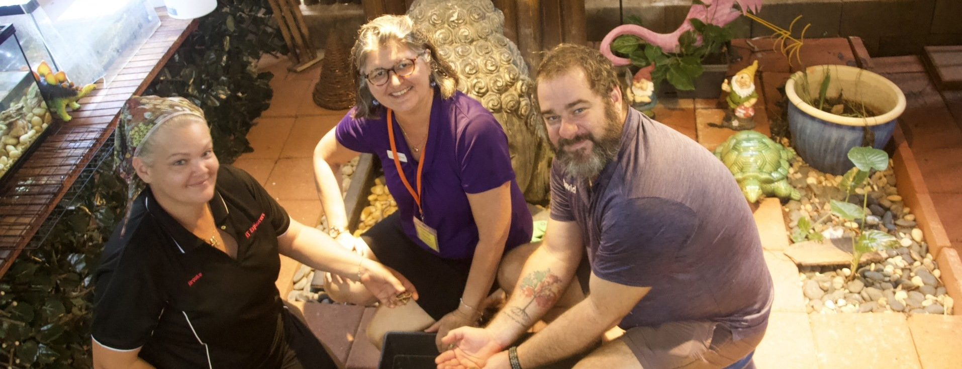 A group of people are sitting on the floor holding hands.