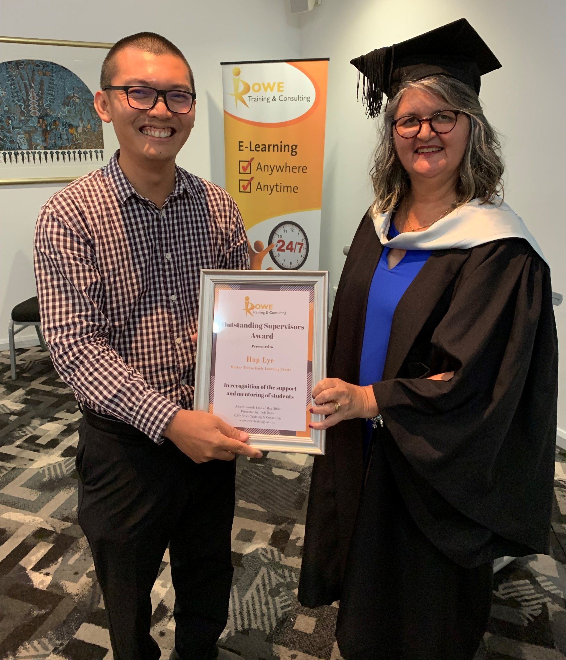 A woman in a graduation cap and gown is holding a certificate