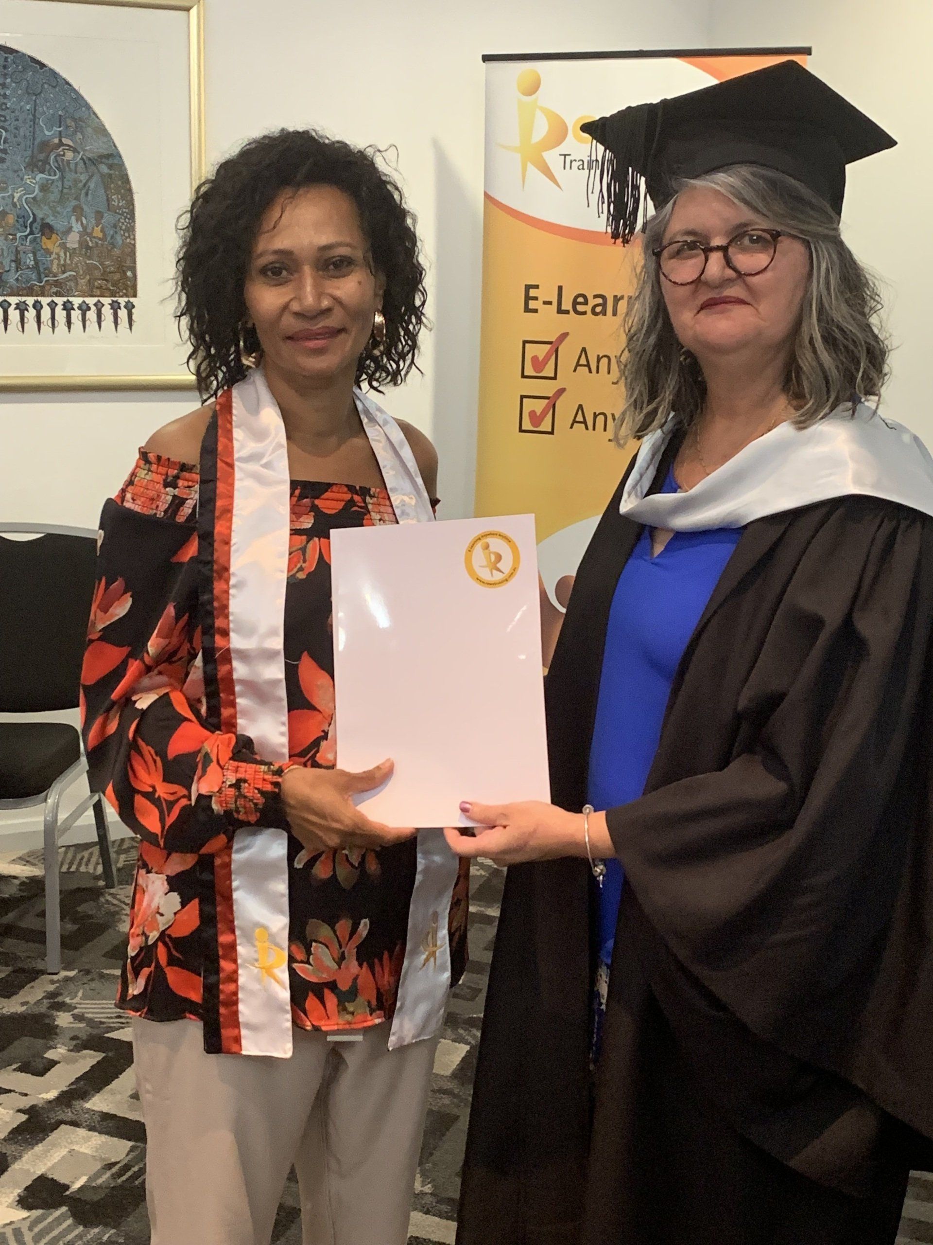A woman in a graduation cap and gown is holding a certificate