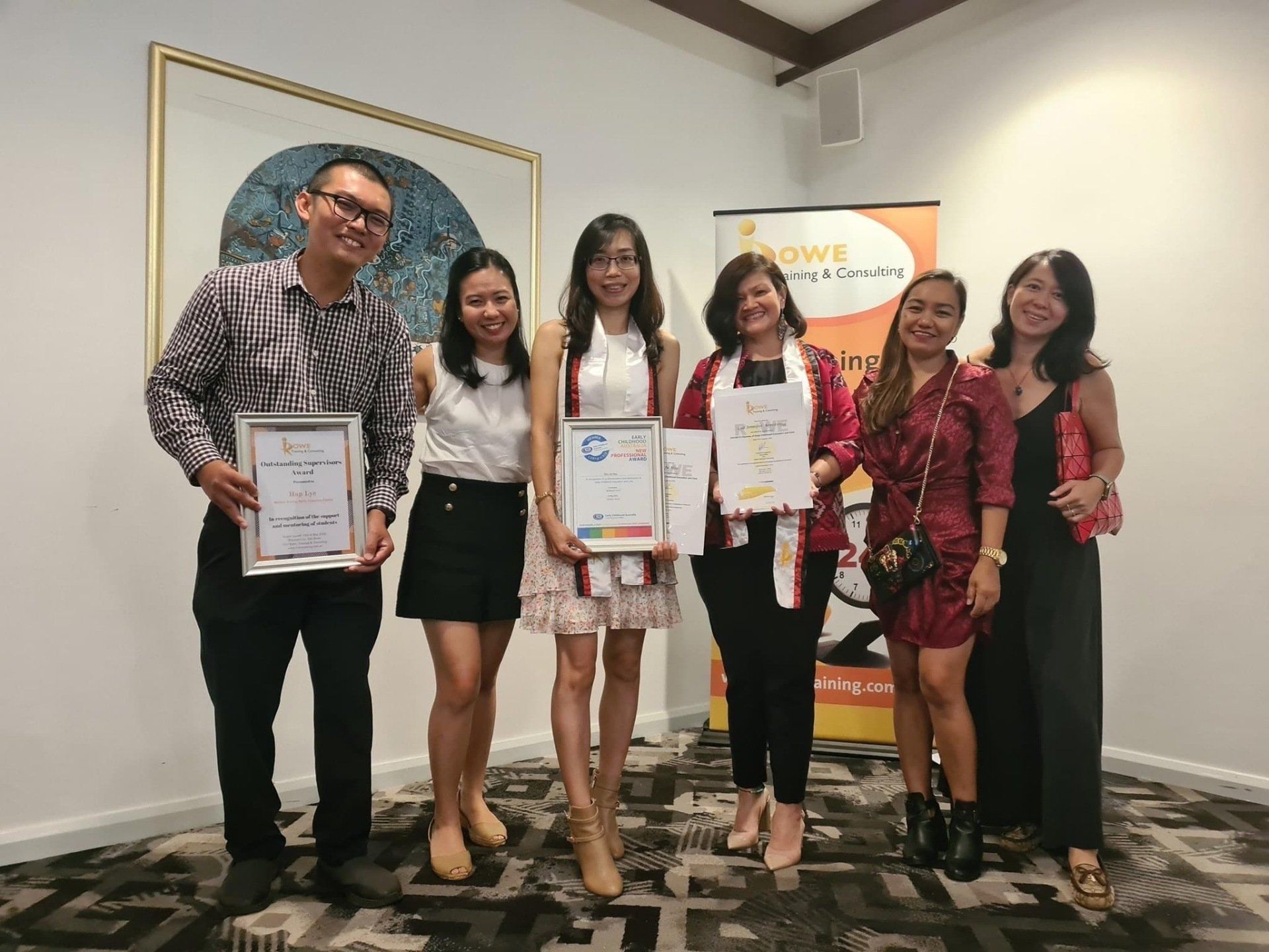 A group of people standing next to each other holding certificates.