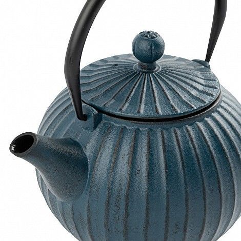 Tetera de hierro fundido azul con diseño acanalado, asa y pico negros, sobre fondo blanco.