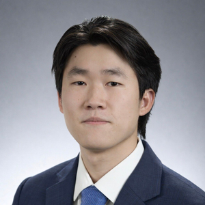 A man with a beard is wearing a blue suit and smiling for the camera.