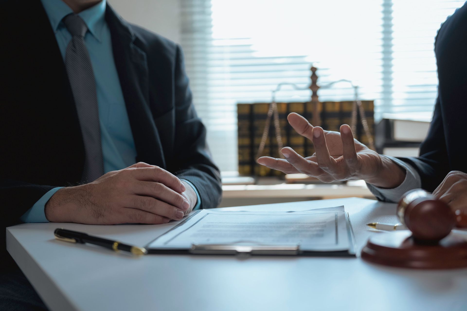 Two people in a business meeting with documents and a gavel on a desk