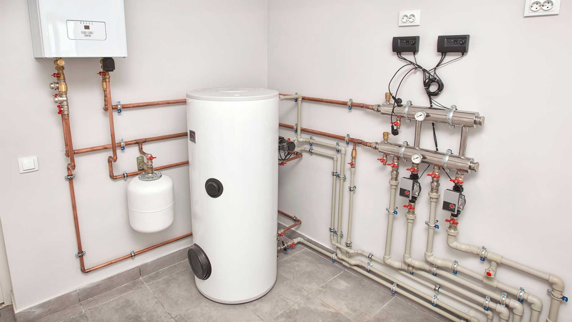 A room with a water heater and a lot of pipes.