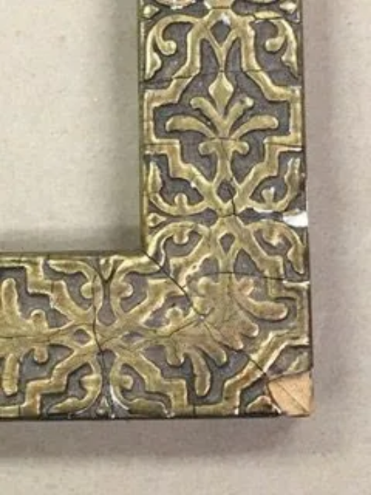 A picture frame with a pattern on it is sitting on a table.