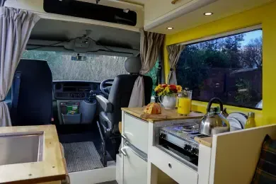 The inside of a camper van with a kitchen and a sink.