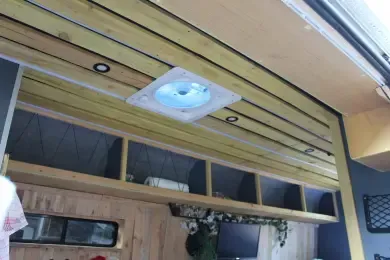 A ceiling fan is hanging from the ceiling of a camper van.
