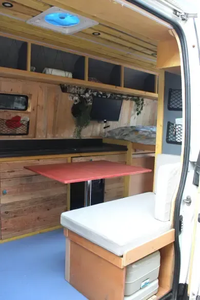 The inside of a camper van with a red table
