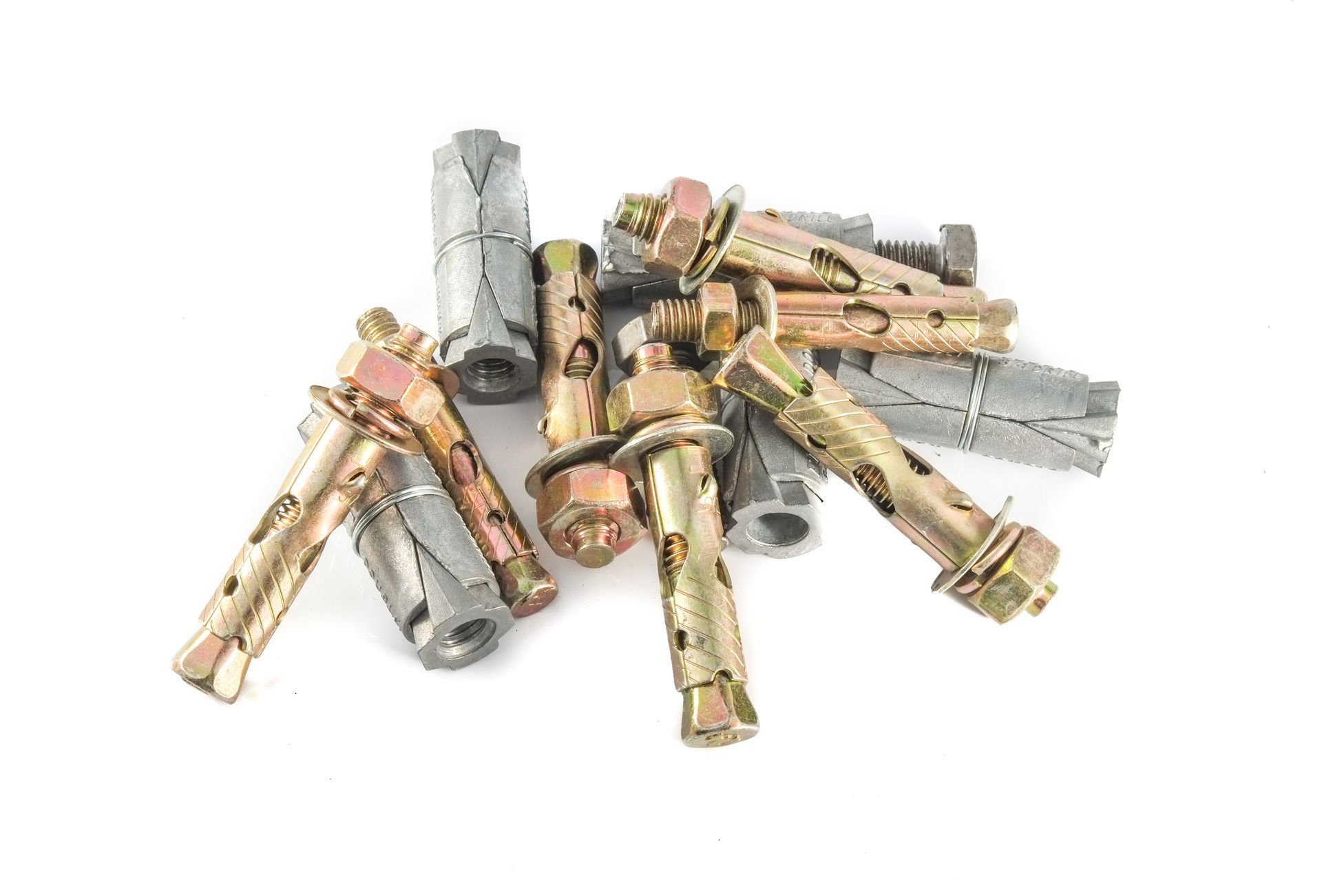 Pile of metal wall anchors and screws on a white background
