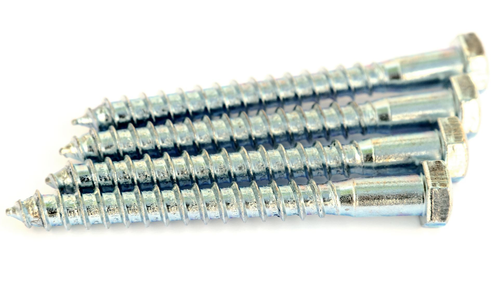 Stack of shiny silver screws on a white background