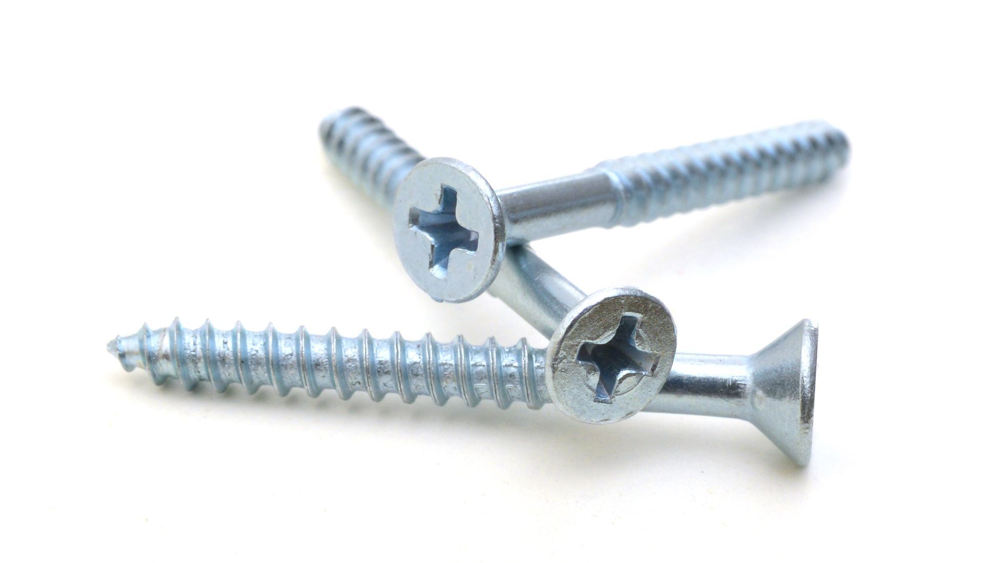 Three silver Phillips-head screws on a white background