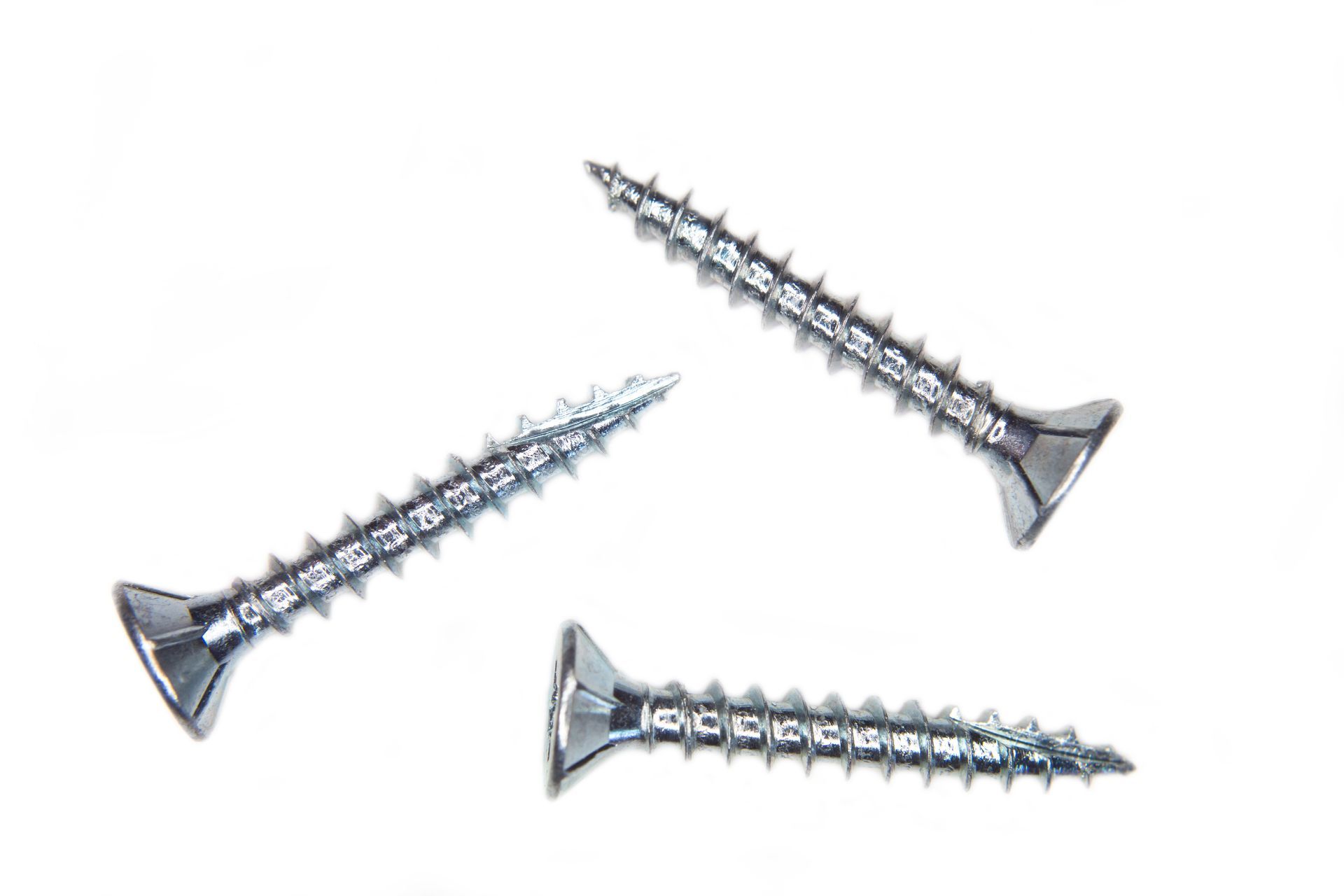Three silver screws arranged on a white background