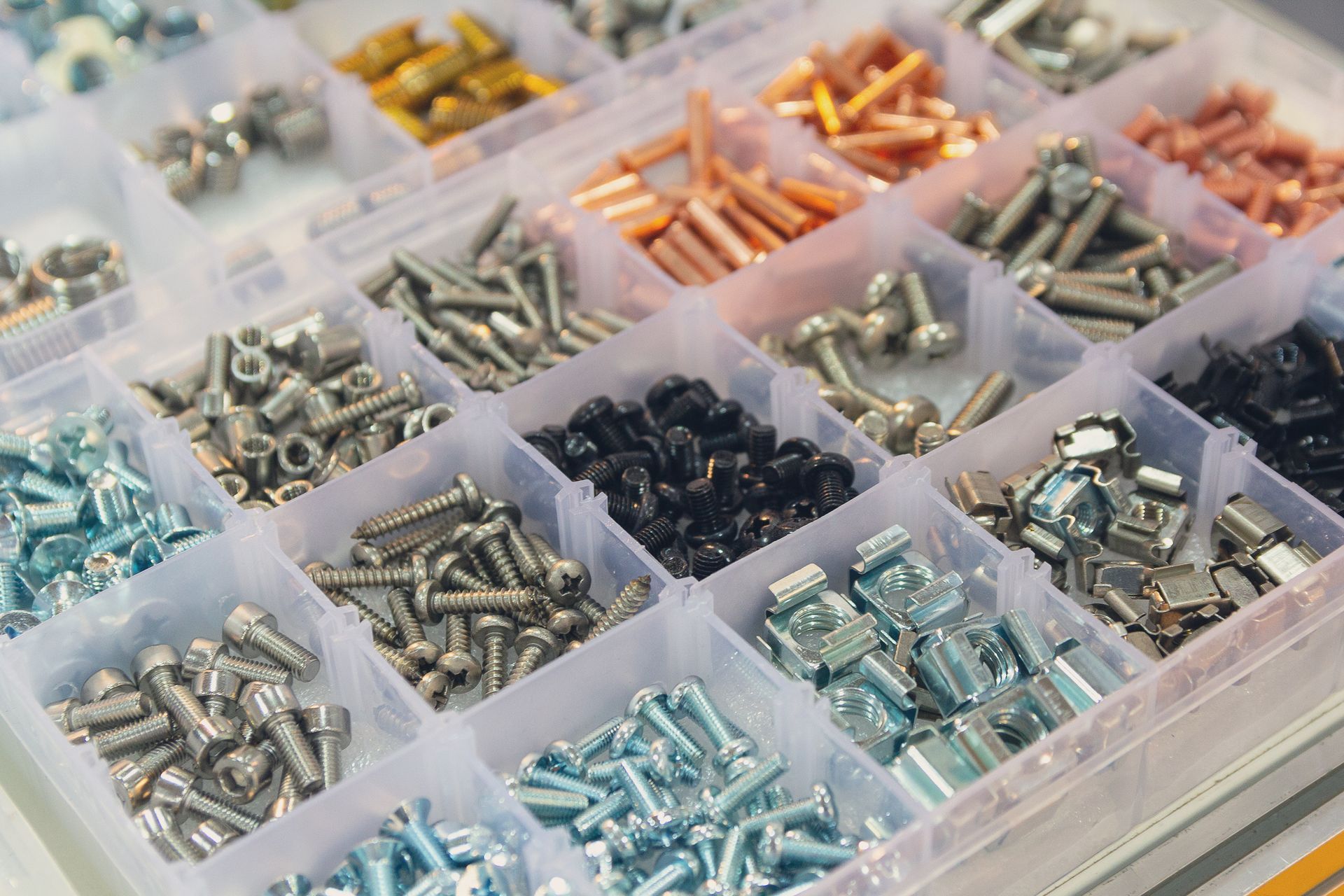 Assorted screws and metal fasteners sorted in small plastic bins