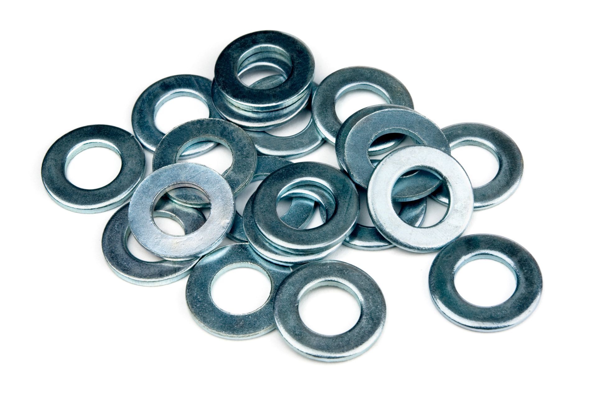 A pile of shiny metal washers on a white background
