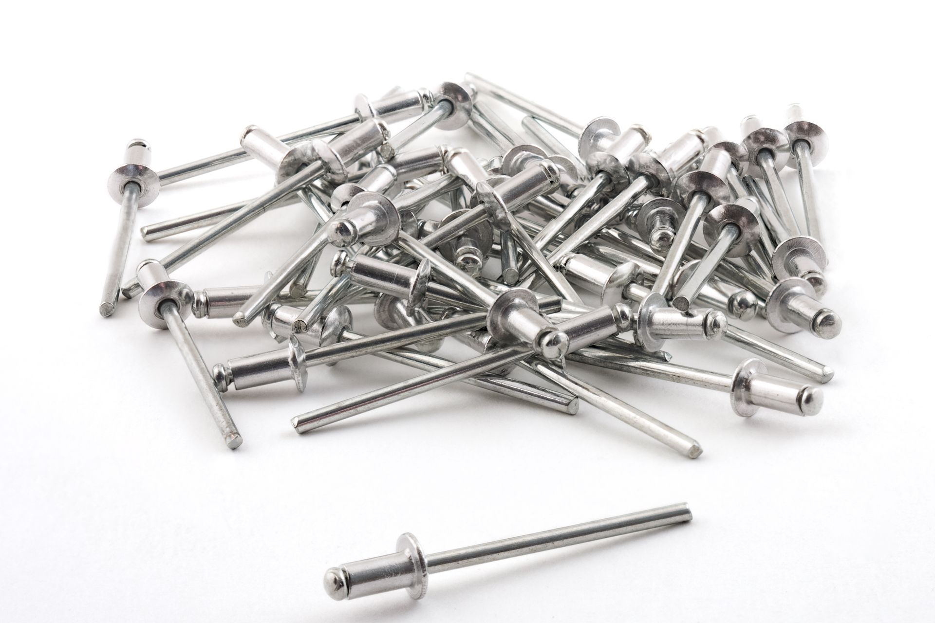 Pile of silver metal rivets on a white background