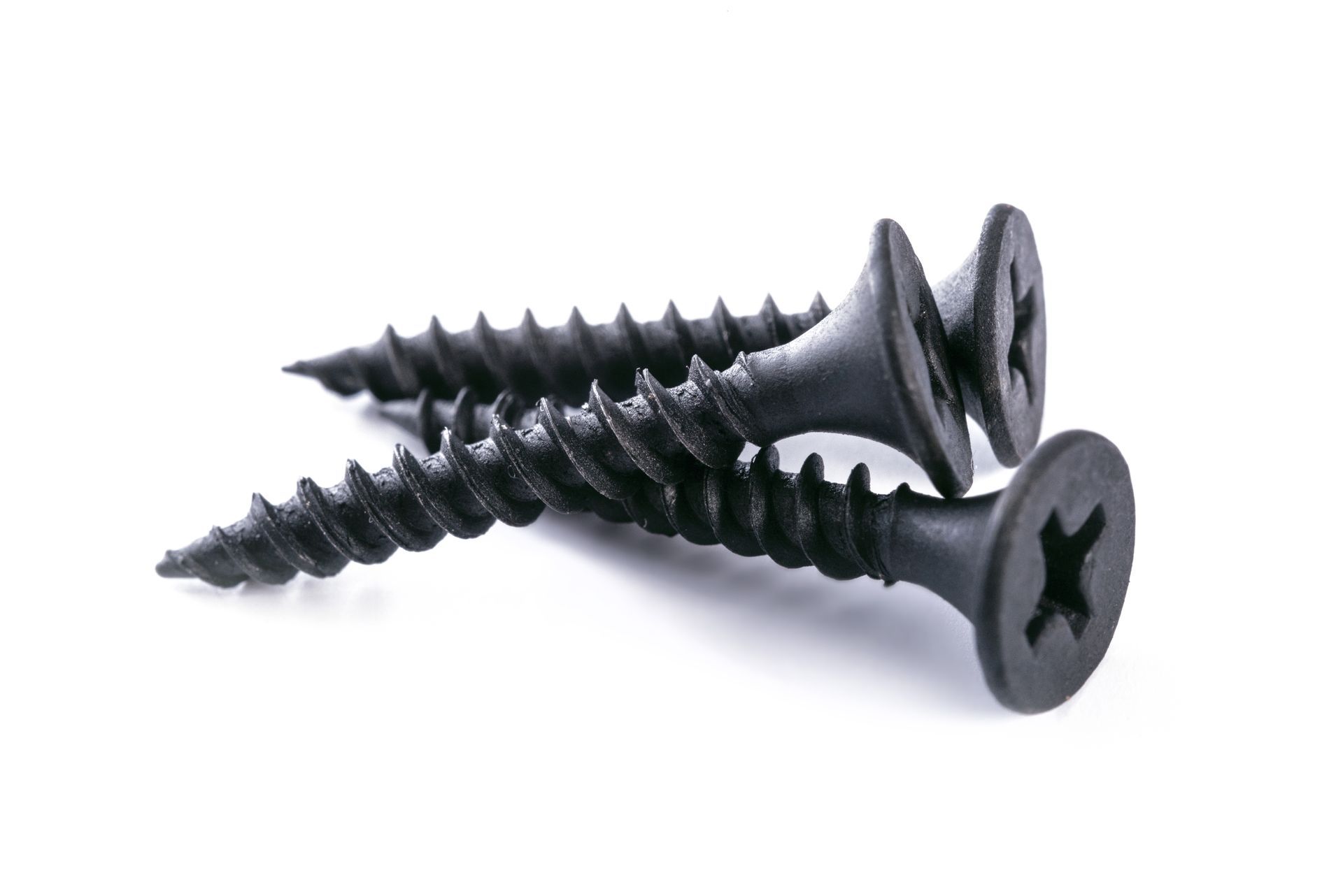 Two black Phillips-head screws with sharp threaded tips on a white background