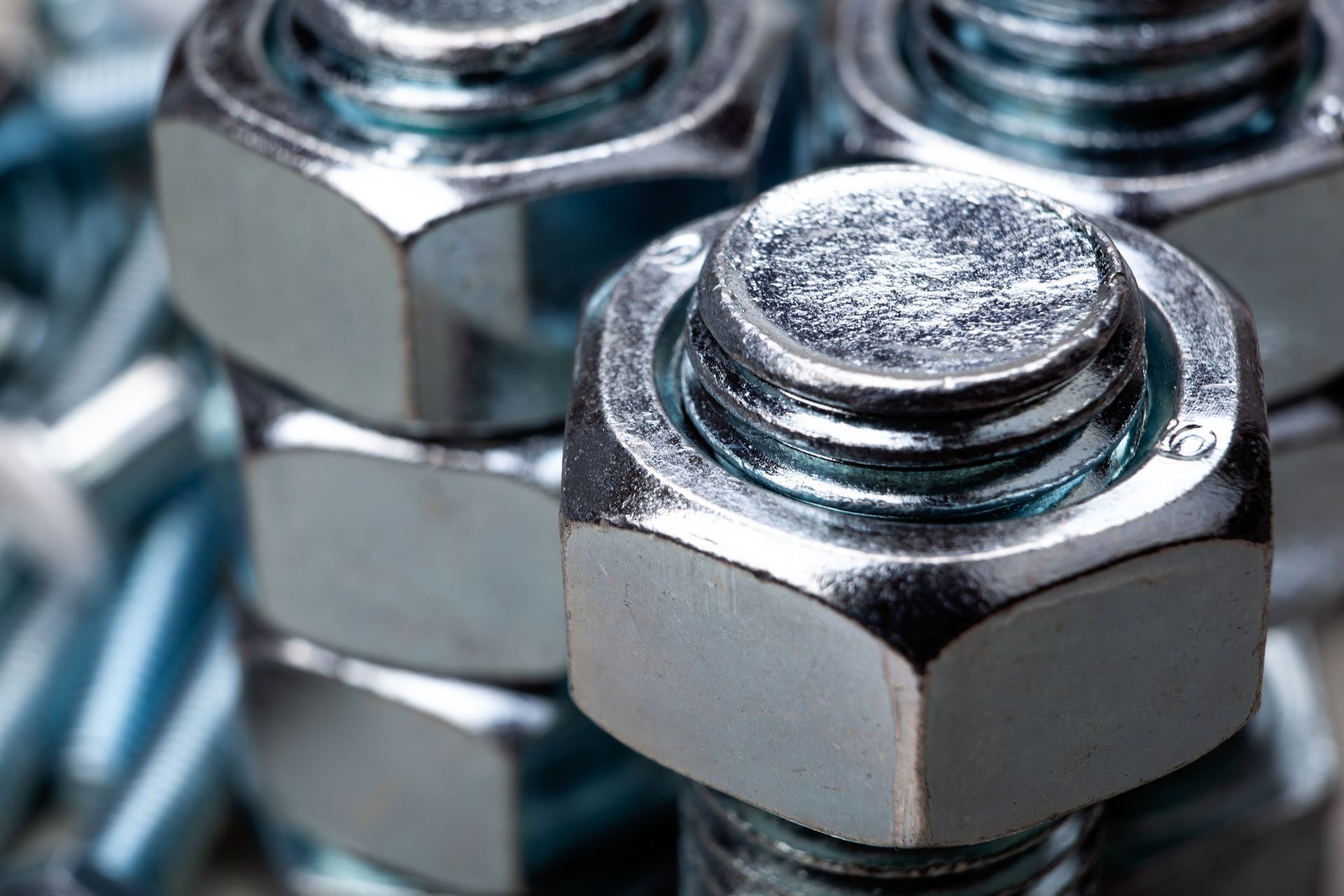 Close-up of shiny metal nuts and bolts stacked together