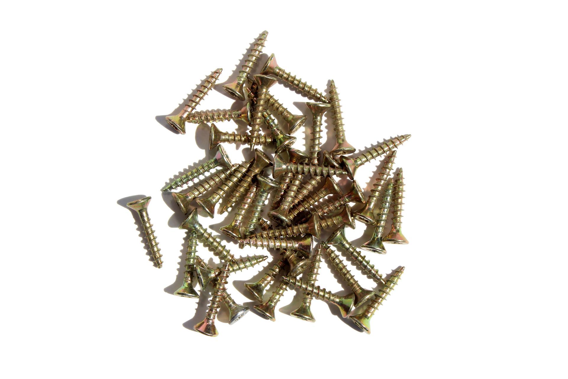 Pile of gold-colored screws on a white background
