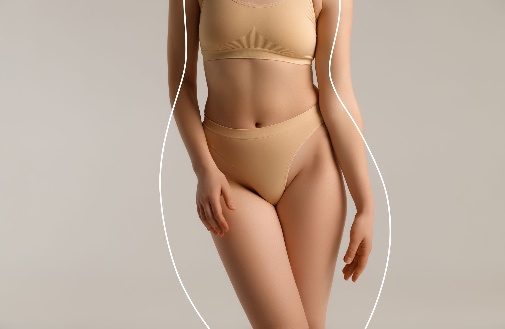 Woman modeling beige lingerie against a plain background