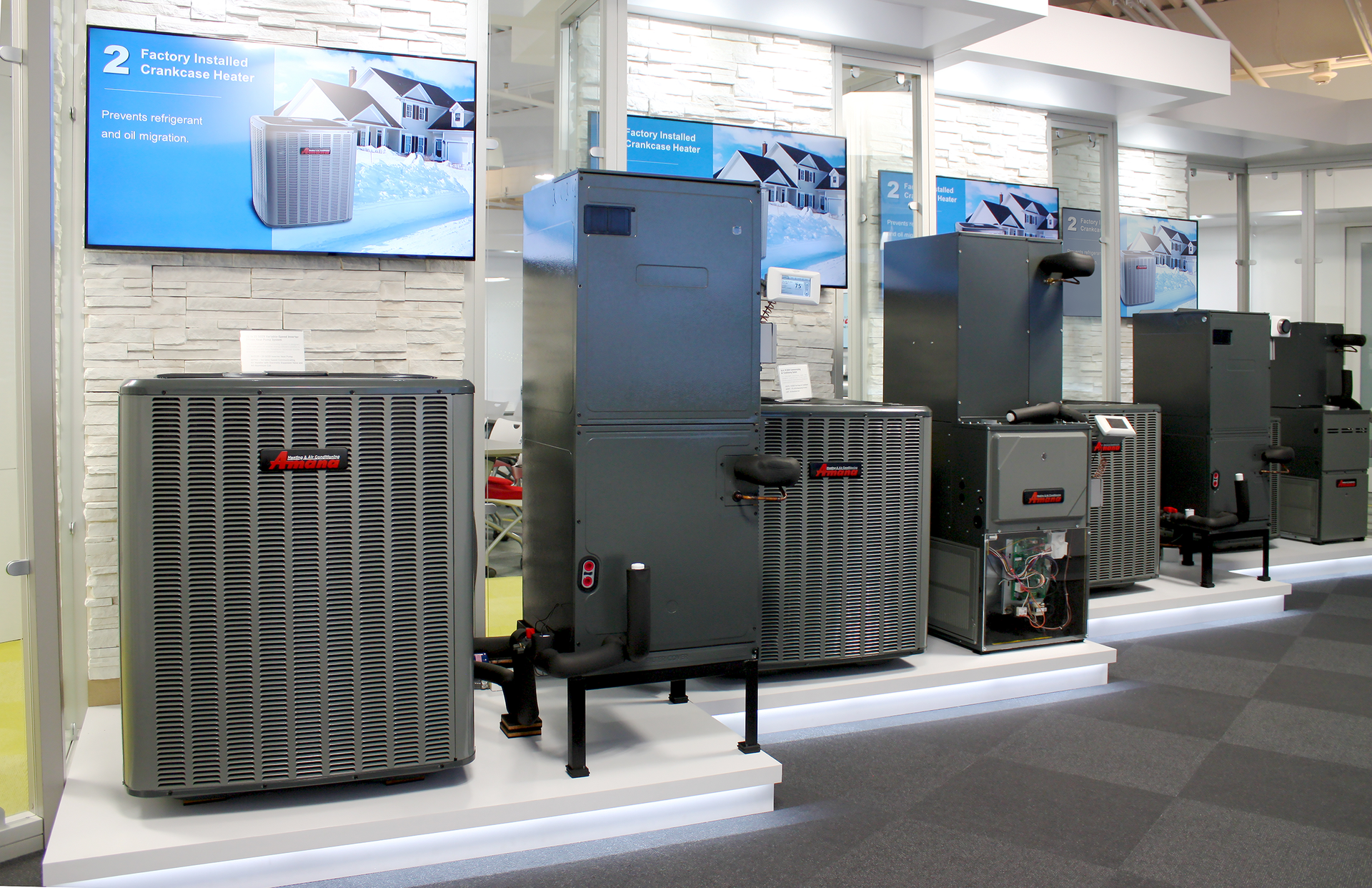 Row of large gray and black air-conditioning units on display in a showroom with blue signage.