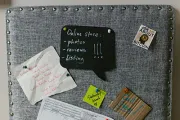 Gray bulletin board with notes: