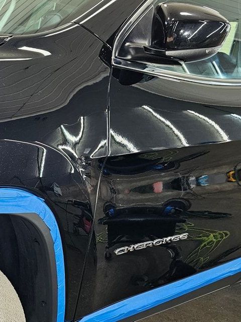 A black car with the word cherokee on the side
