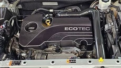 A close up of the engine of a car with the hood open.