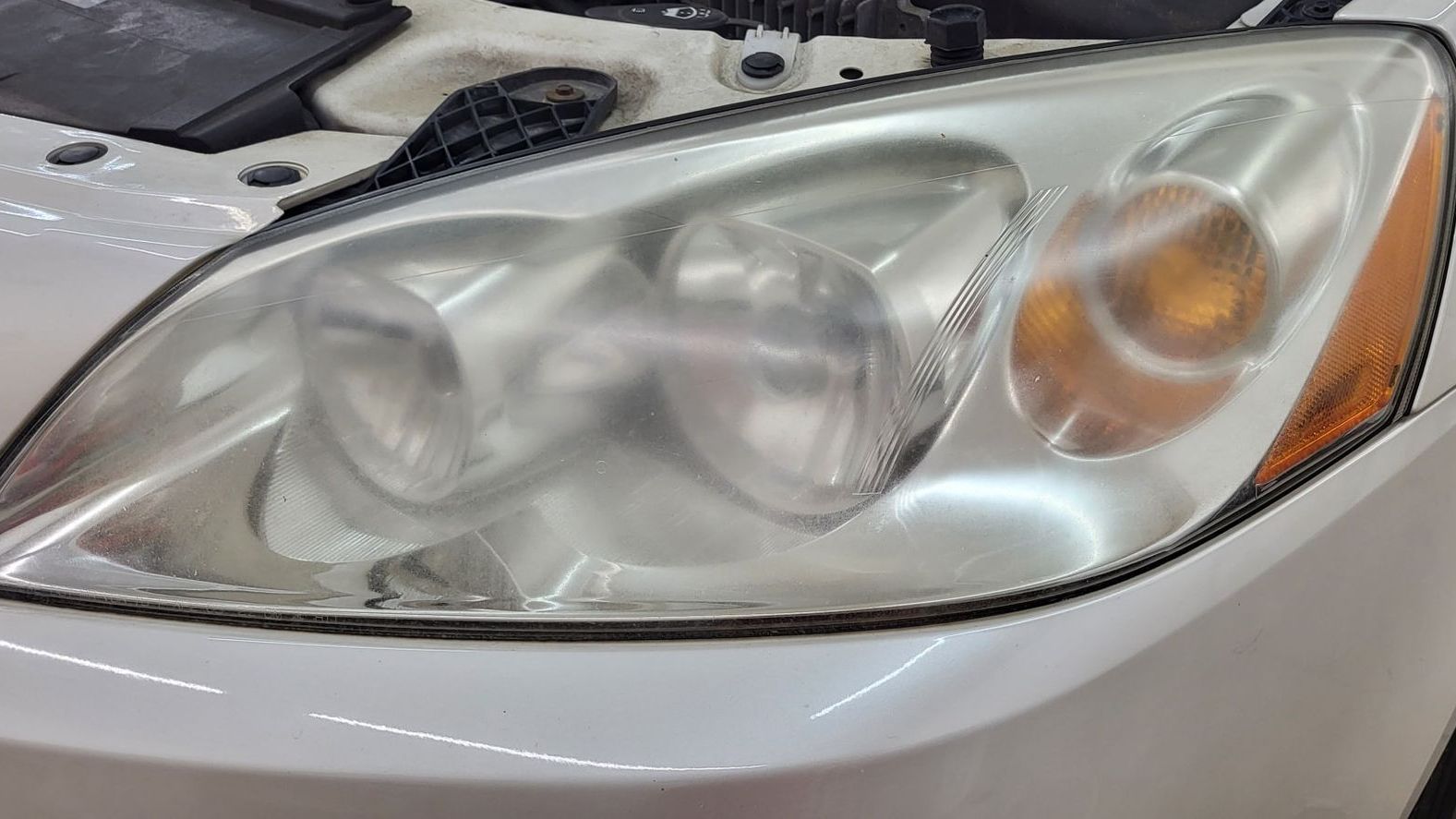 A close up of a white car 's headlight.