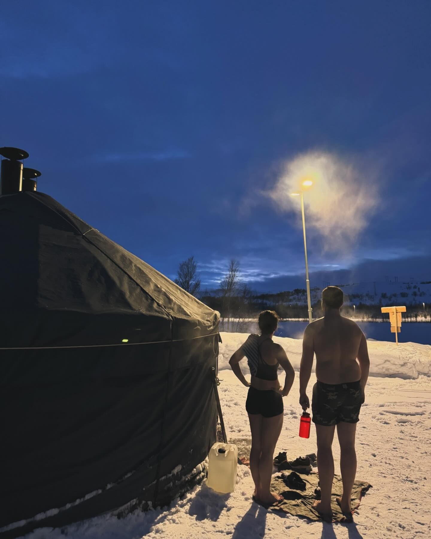 Flere mennesker tar sauna i både telt- og tønnesauna i fjæra (Ytrebyfjæra).