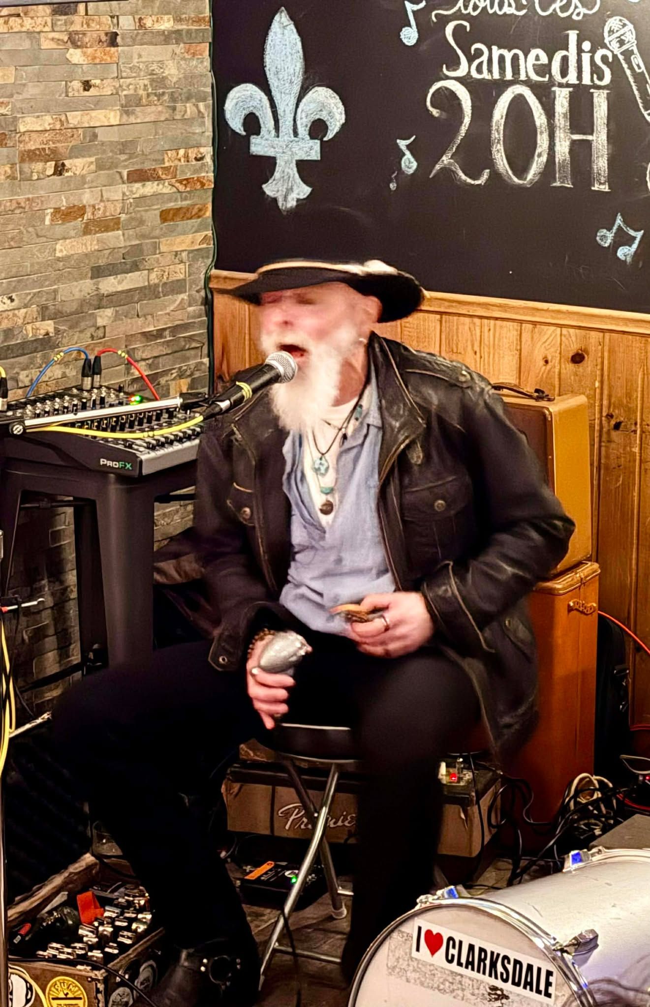A man sitting playing the harmonica