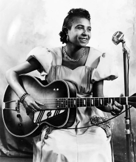 Femme afro-américaine assise, jouant de la guitare