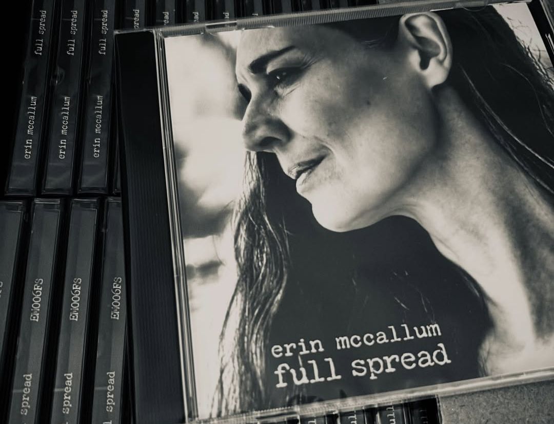 A copy of Erin McCallum's CD Full Spread, on top of an open box full of the new album.