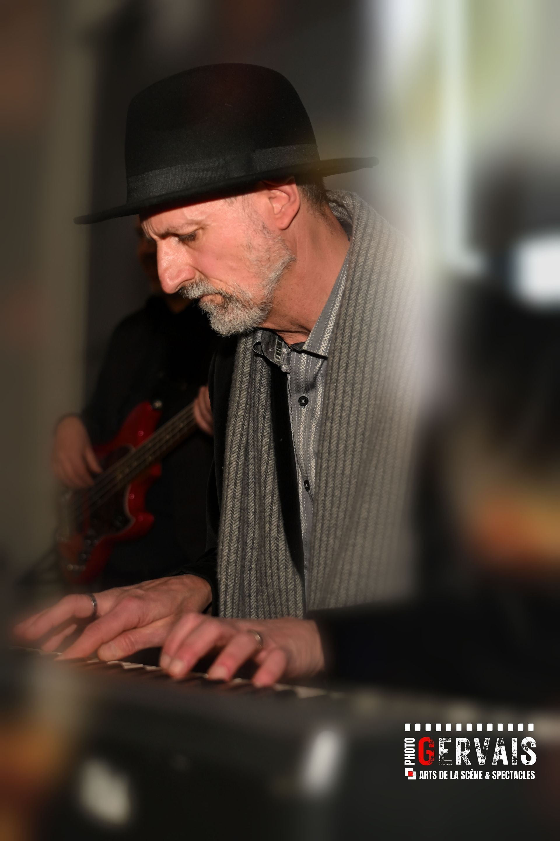 A man wearing a black hat playing a keyboard